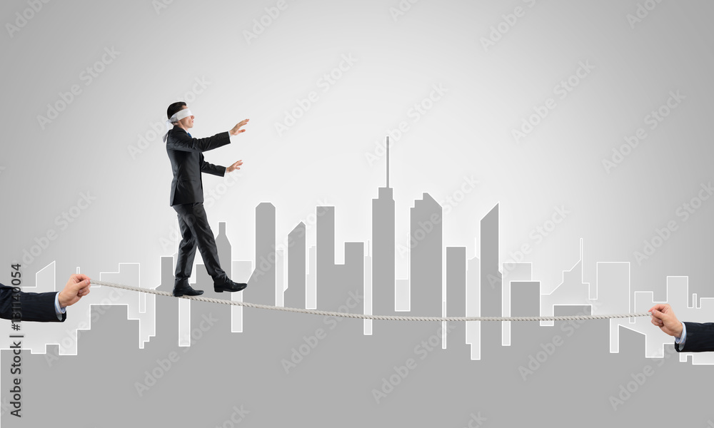 Business concept of risk support and assistance with man balancing on rope Business concept of risk support and assistance with man balancing on rope