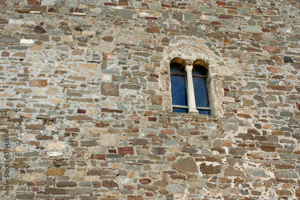 The fragment of the reconstructed stony wall with the small gothic window in the medieval Genoese fortress Soldaia in Sudak, Crimea. The fragment of the reconstructed stony wall with the small gothic window in the medieval Genoese fortress Soldaia in Sudak, Crimea.