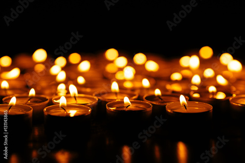 Burning candles. Many burning candles shining in the dark. Shallow depth of field.