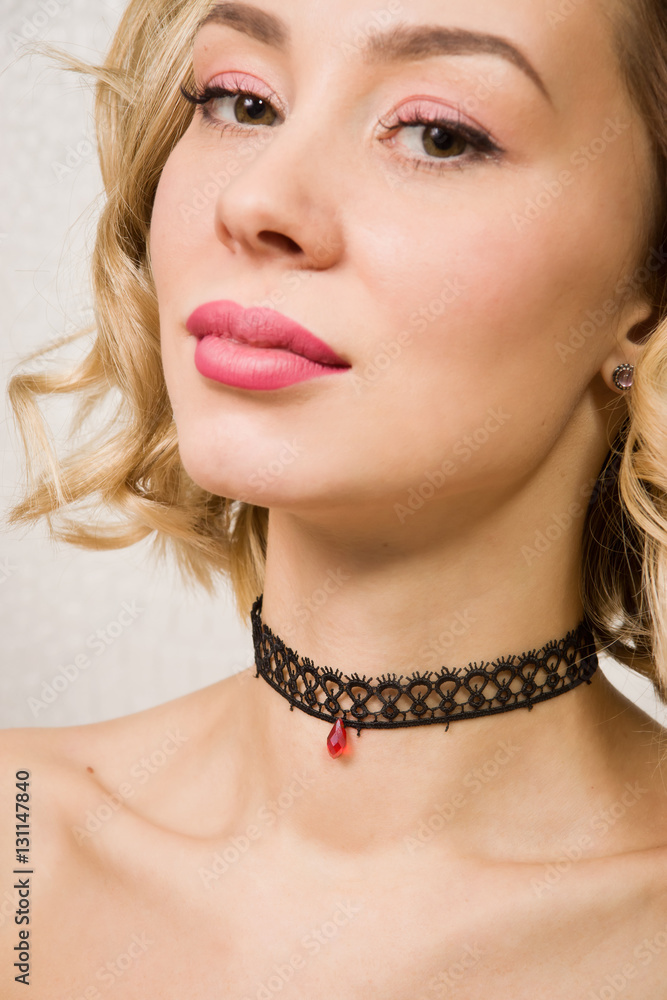 Beautiful woman showing her neck with a choker on it