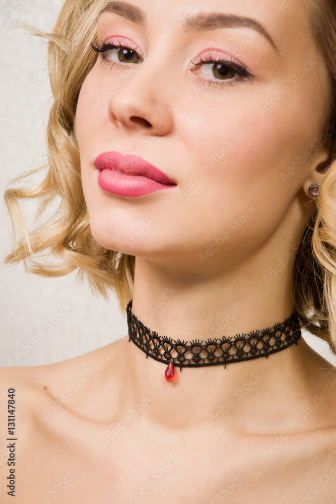 Beautiful woman showing her neck with a choker on it Beautiful woman showing her neck with a choker on it