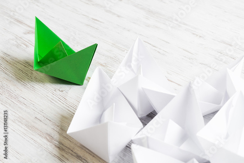 Business leadership concept with white and color paper boats on wooden table © adam121