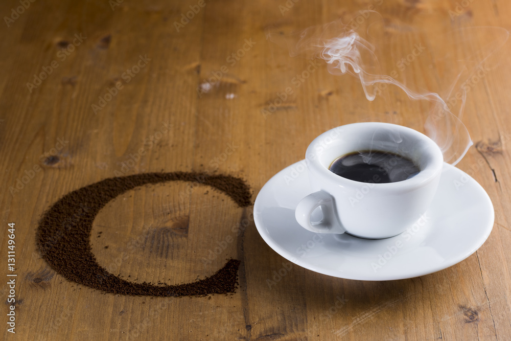 Obraz premium small cup reversed with coffee beans scattered on the wooden table