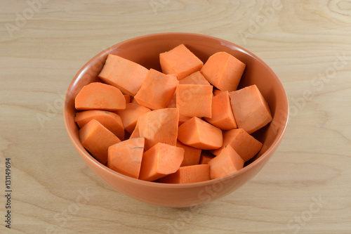 Raw uncooked yam cubes in orange bowl