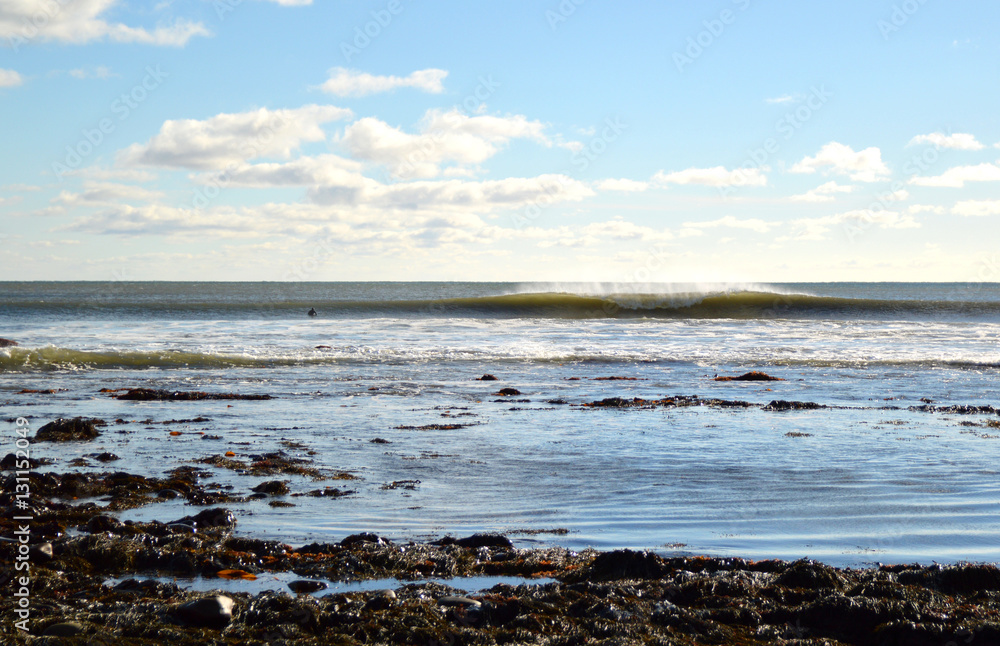 surfer waiting in the water looking at a left and right breaking surfer waiting in the water looking at a left and right breaking