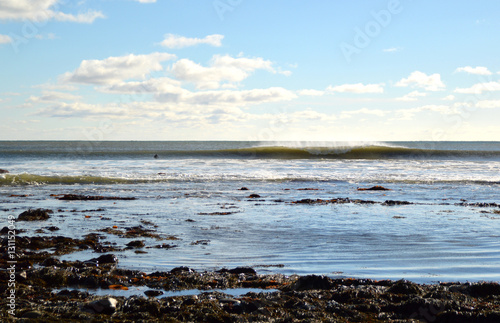 surfer waiting in the water looking at a left and right breaking