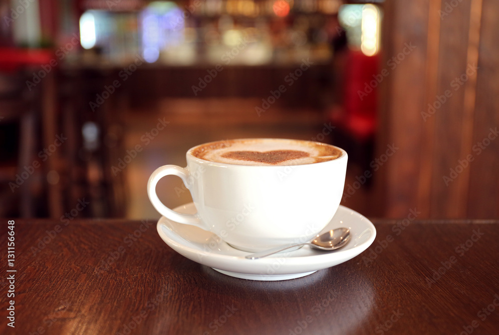 Cup with hot tasty coffee on wooden table in cafe, close up view Cup with hot tasty coffee on wooden table in cafe, close up view