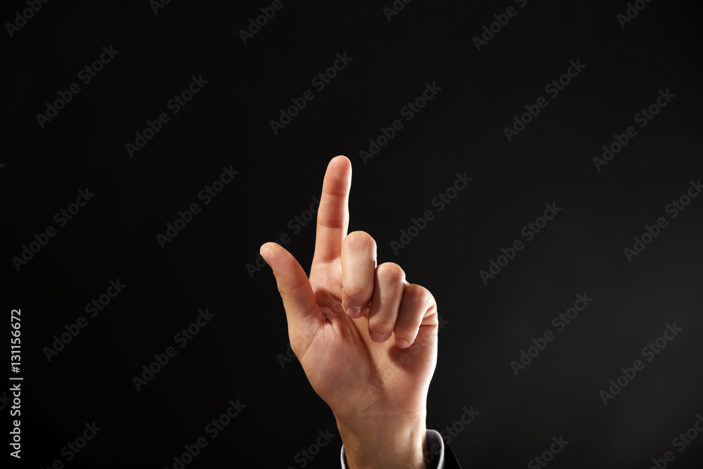 Male hand with finger pointing on dark background Male hand with finger pointing on dark background