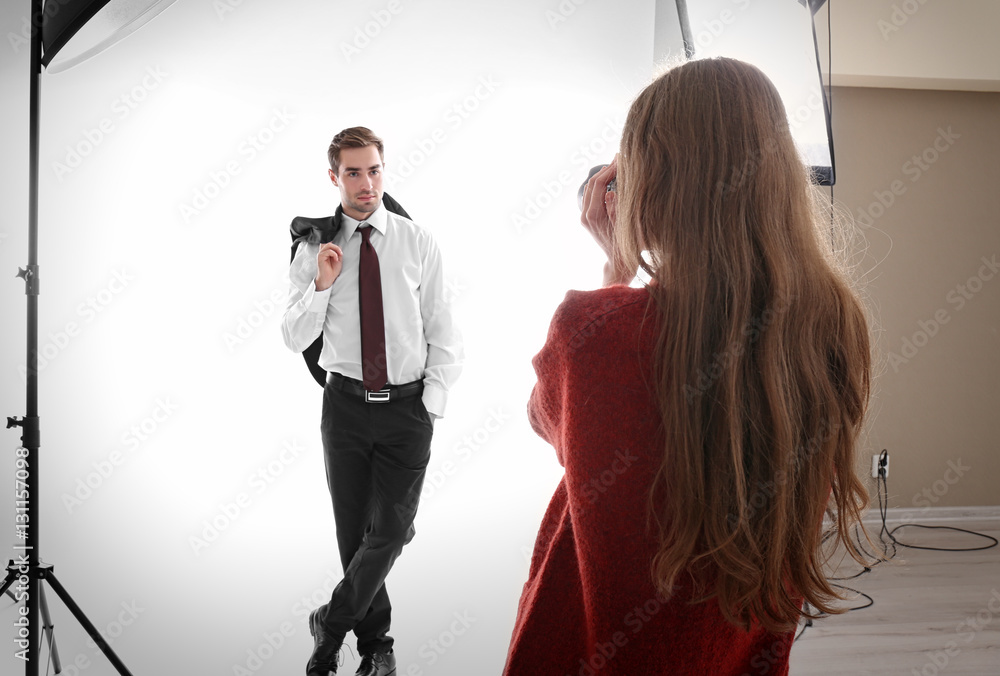 Fototapeta premium Photographer taking picture of model in studio
