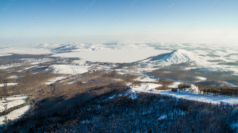 Russian Ural mountains in winter. Aerial view lake, white infinity