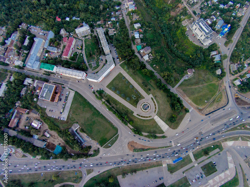 Autumn in city. Panoramic aerial view at road, forest, river.