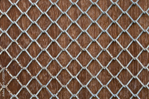 Metal mesh grid on plank wood.