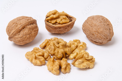 Walnuts and walnut kernels on white background