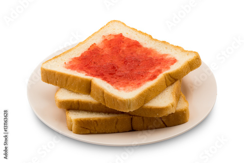 Pile of sliced bread with strawberry jam in a plate