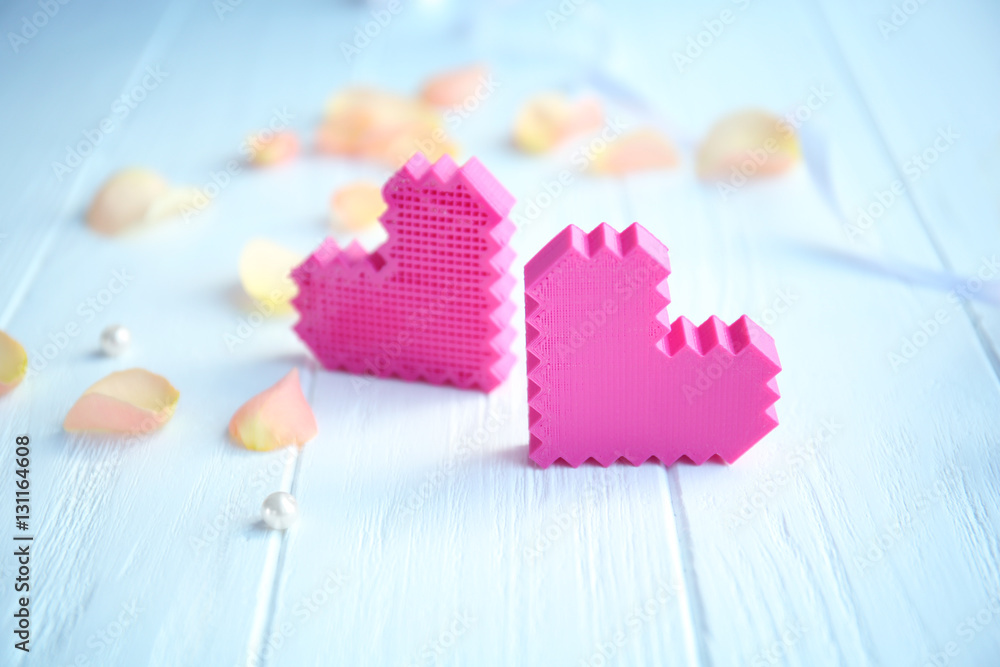 Naklejka premium Pink hearts with flower petals on table