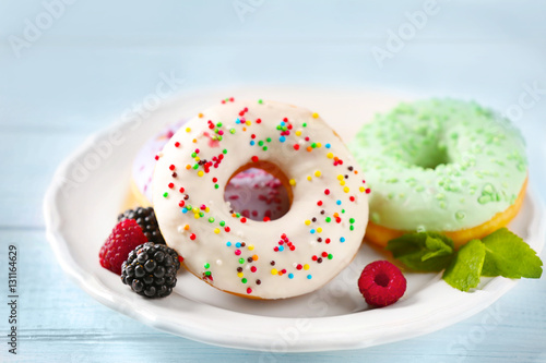 Plate with delicious donut and berries, closeup