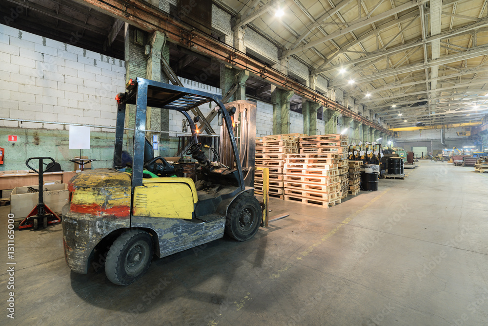 Forklift truck pulled up to a pile of wooden pallets. Forklift truck pulled up to a pile of wooden pallets.