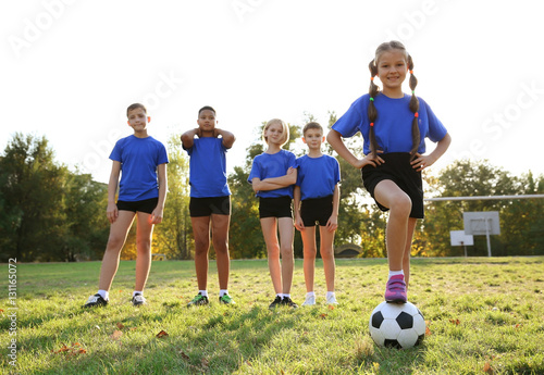Cute kids playing football on field