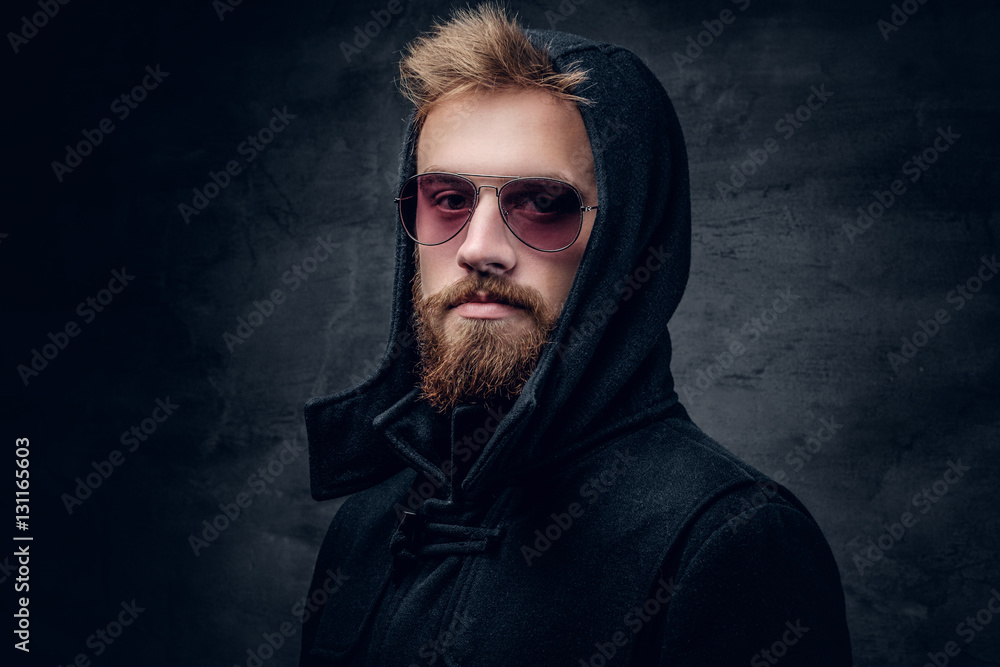 Fototapeta premium A bearded male in sunglasses and in a hood.