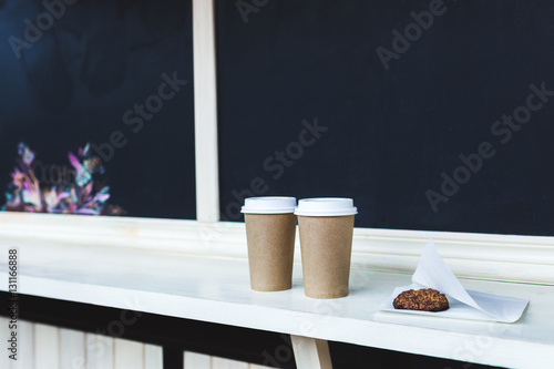 Two cups of coffee to go and oat cookies at the bar photo