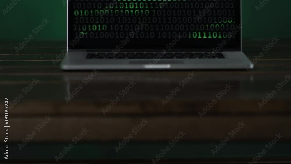 laptop with vertical binary code standing at the desk laptop with vertical binary code standing at the desk
