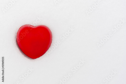 Red heart on the white snow