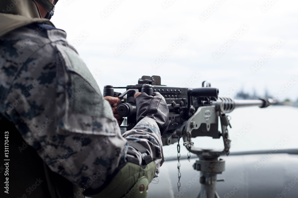 Fototapeta premium Selected focus Navy soldier hand on machine gun on