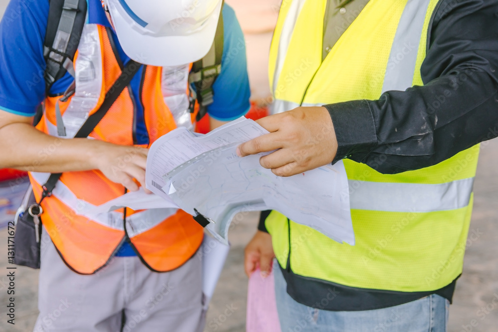 two foreman wearing protective clothing discussion on a construction site as background two foreman wearing protective clothing discussion on a construction site as background