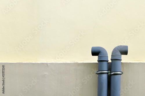 Urban background. Two black pipe on the background of a white wall stucco walls. Space for text.