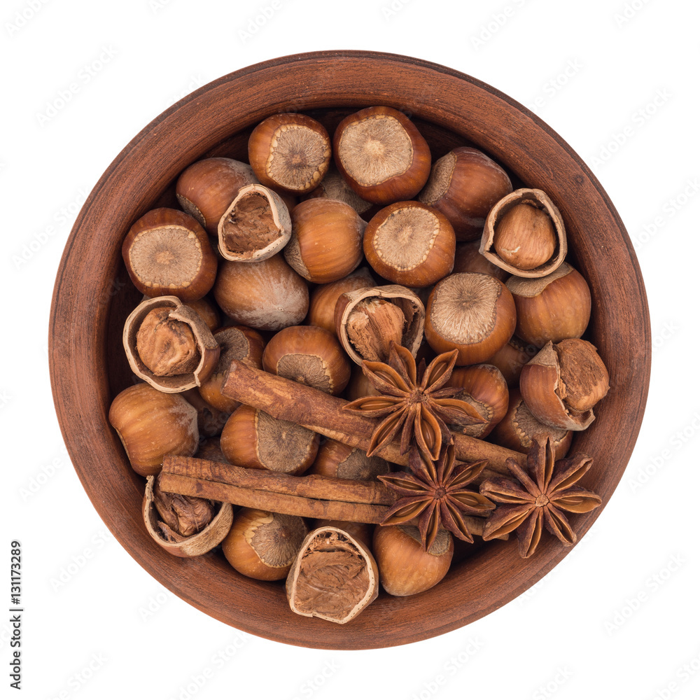 Hazelnuts in a brown plate. Isolated on white background. Hazelnuts in a brown plate. Isolated on white background.