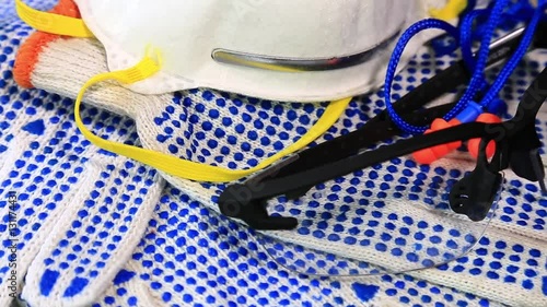 Thin work gloves with  blue pimples, protective glasses, respirators and ear plugs on a rotating surface, Personal protective equipment background. Industrial safety concept.