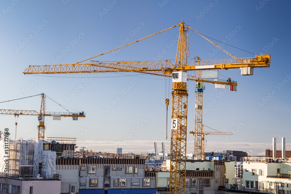 Construction site with tower cranes against clear sky.