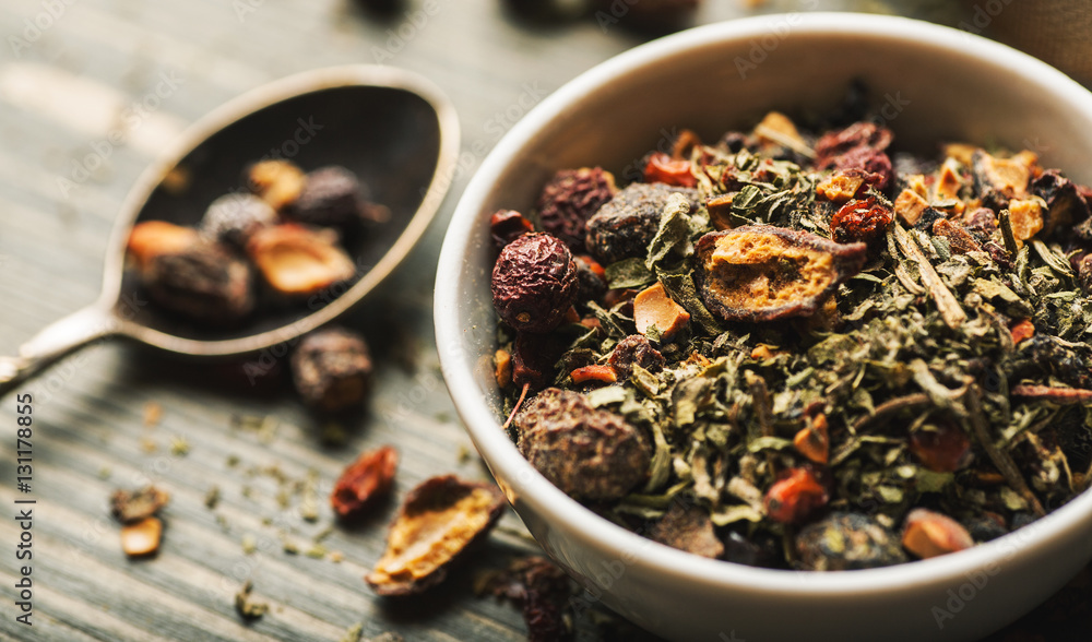 Dry herbal tea in metal stainer on wooden table Dry herbal tea in metal stainer on wooden table