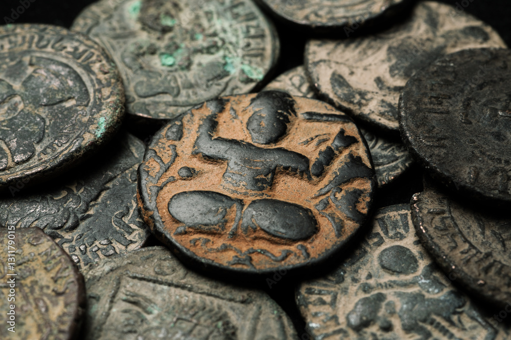 Ancient islamic copper coin in pile of other coins