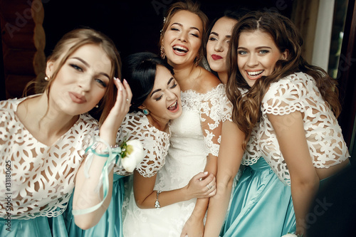 Smiling bridesmaids leans to gorgeous bride