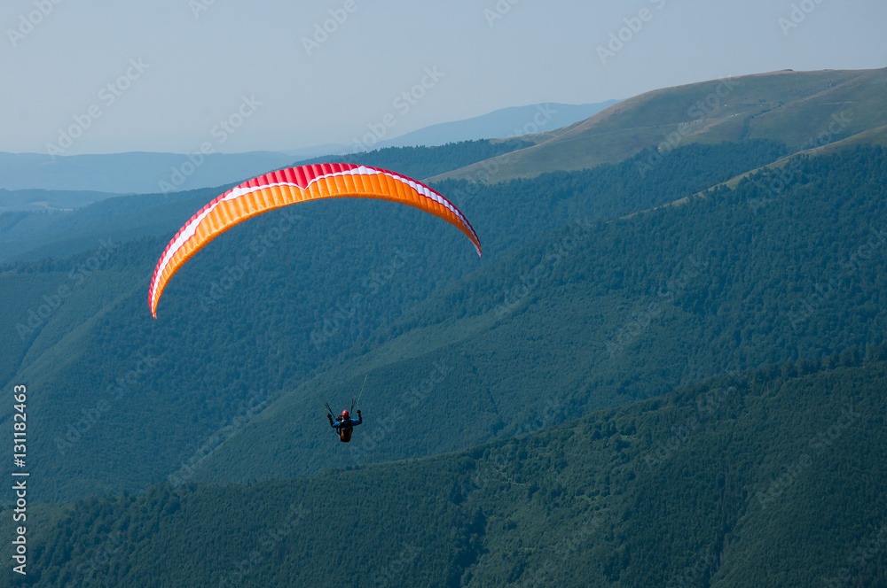 Paragliding in the Carpathians mountains. Pilot flying in the sky under mountains. Paragliding in the Carpathians mountains. Pilot flying in the sky under mountains.
