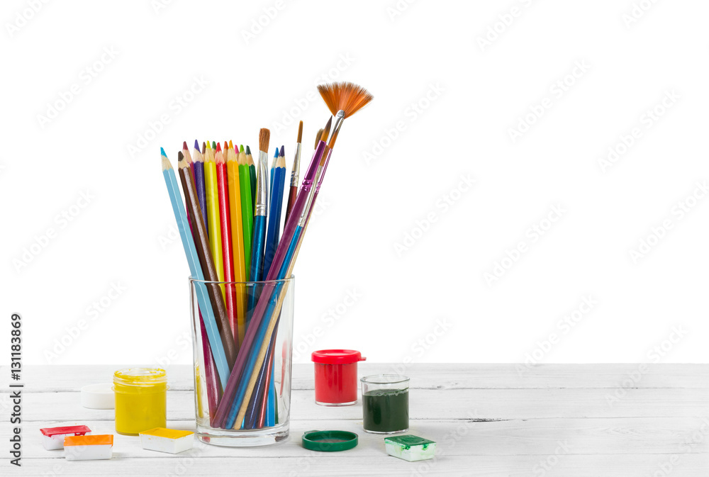 Obraz premium Colored pencils and brushes to draw in glass and watercolor pain
