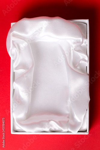 gift box with satin white pillow on red background
