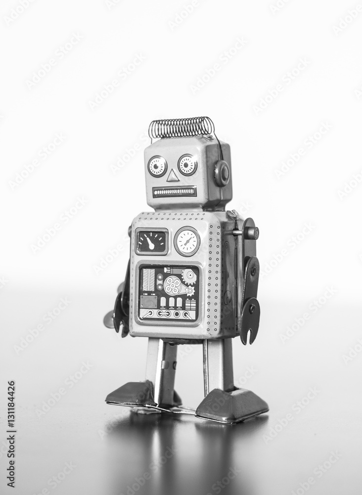 Fototapeta premium Blechroboter-Spielzeug, Methapher für Chatbot / Socialbot und Algorithmen, Hochformat schwarz weiß