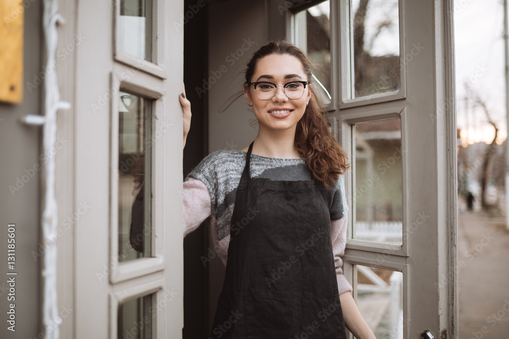 Pretty young woman confectioner standing near cafe