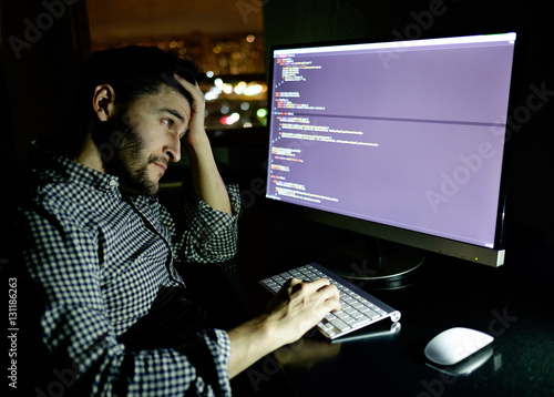 Stressed software developer with computer at home office