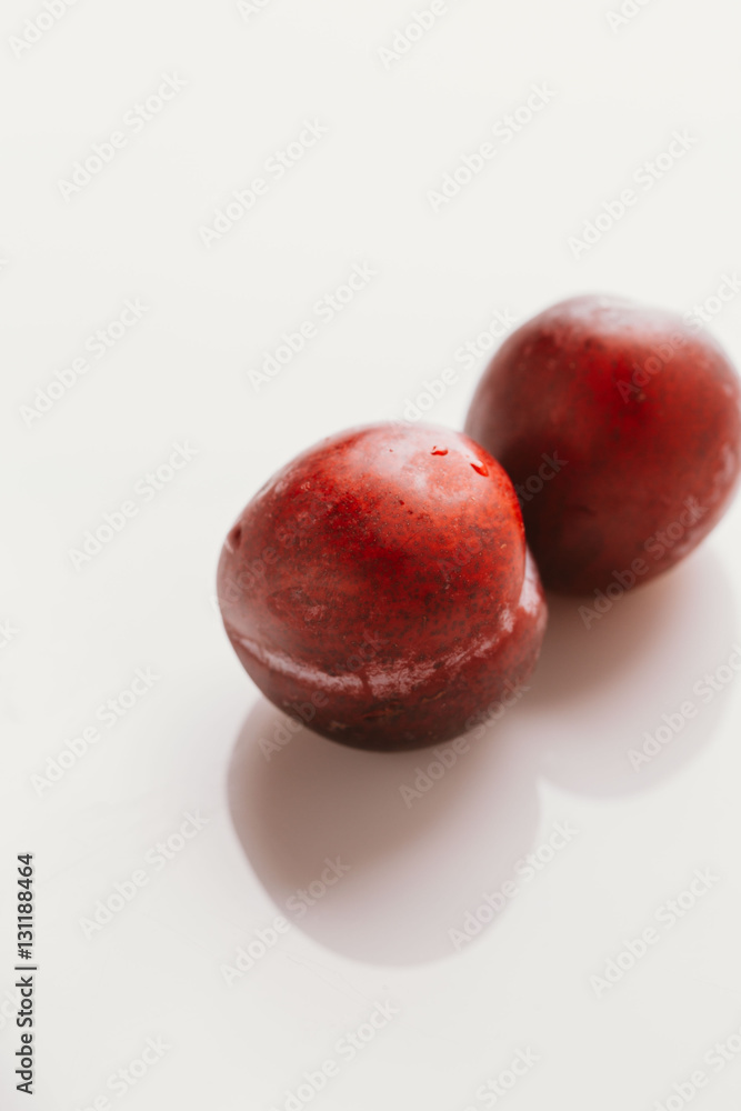 plum fruit whole on a light background closeup plum fruit whole on a light background closeup