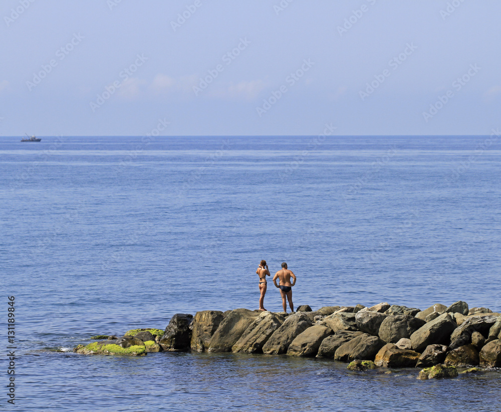 people are resting on a stone pier in Khosta, Russia people are resting on a stone pier in Khosta, Russia