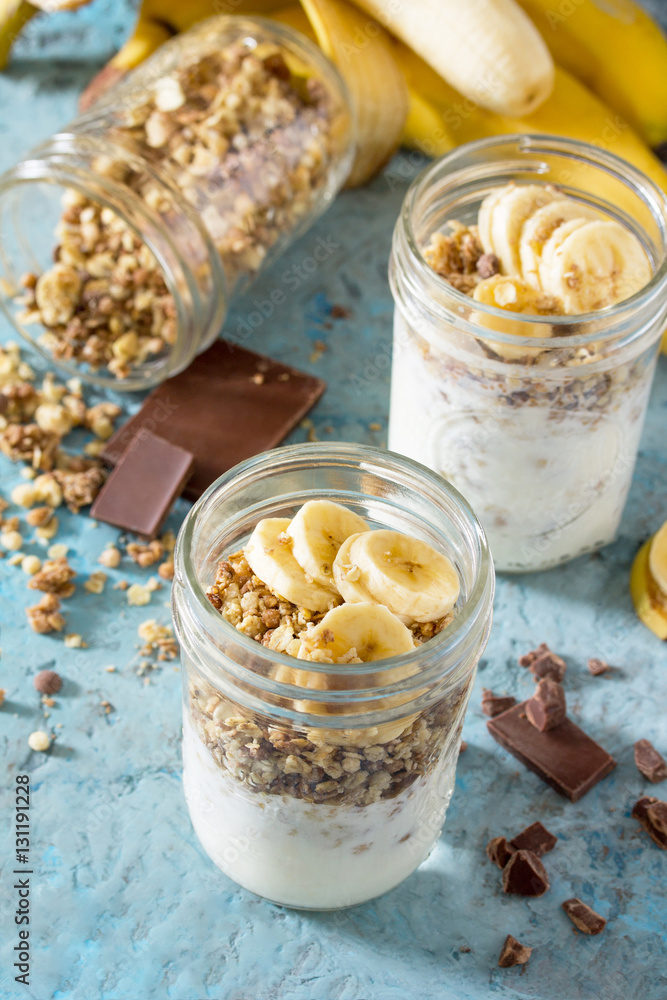 Granola. Granola with yogurt, chocolate and banana on blue concr