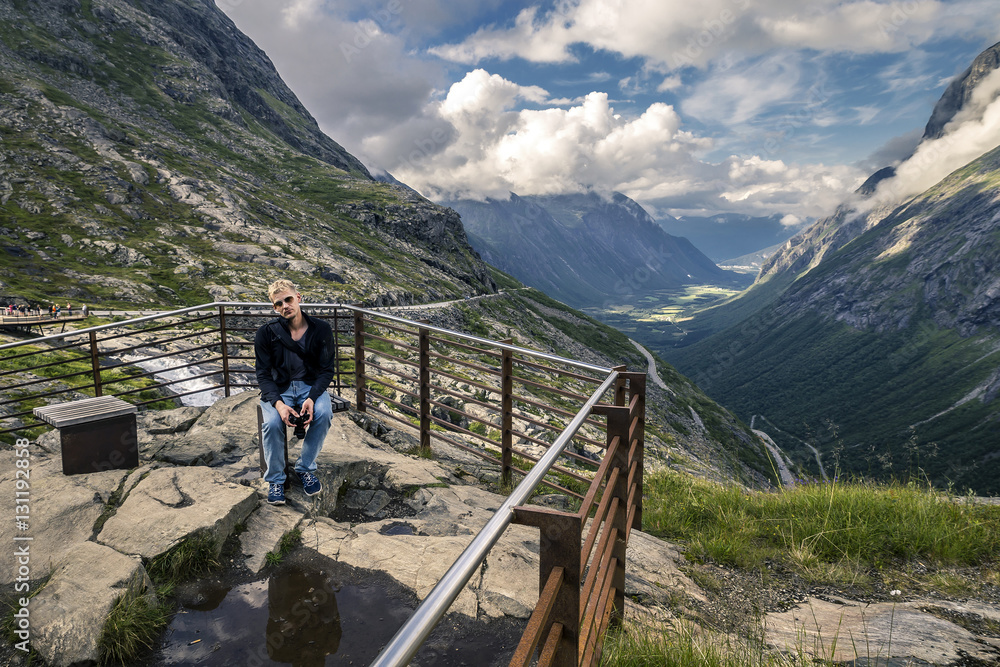 Young man is hiking in Trollstigen, Norway