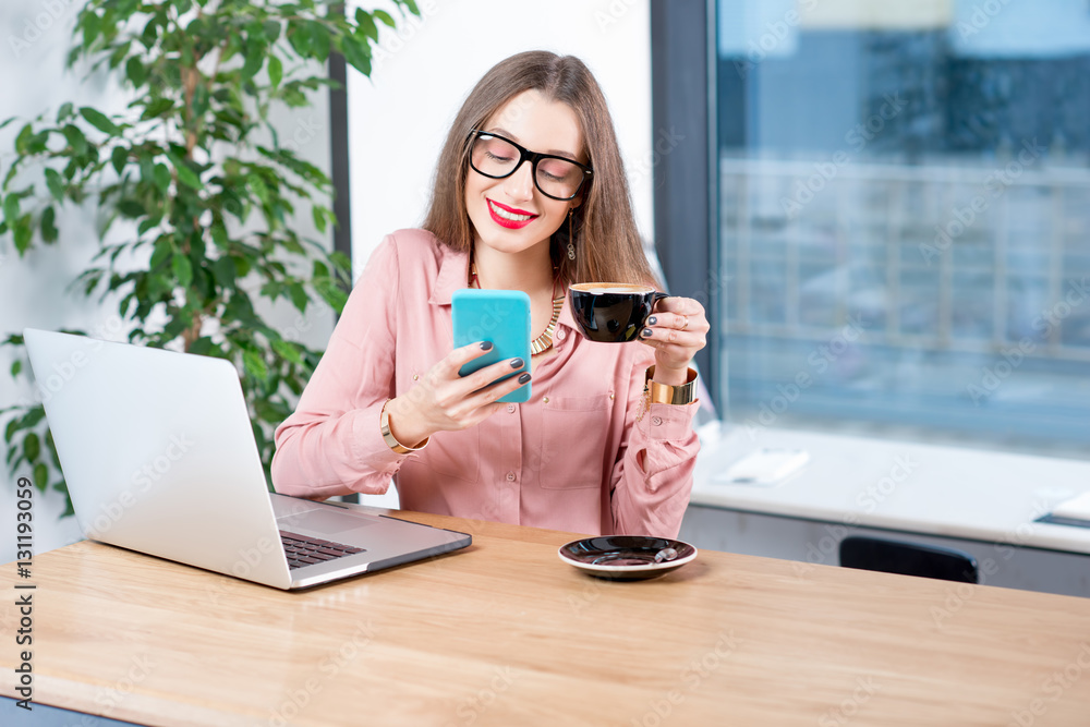 Businesswoman sitting with coffee, smartphone and laptop at the cafe Businesswoman sitting with coffee, smartphone and laptop at the cafe