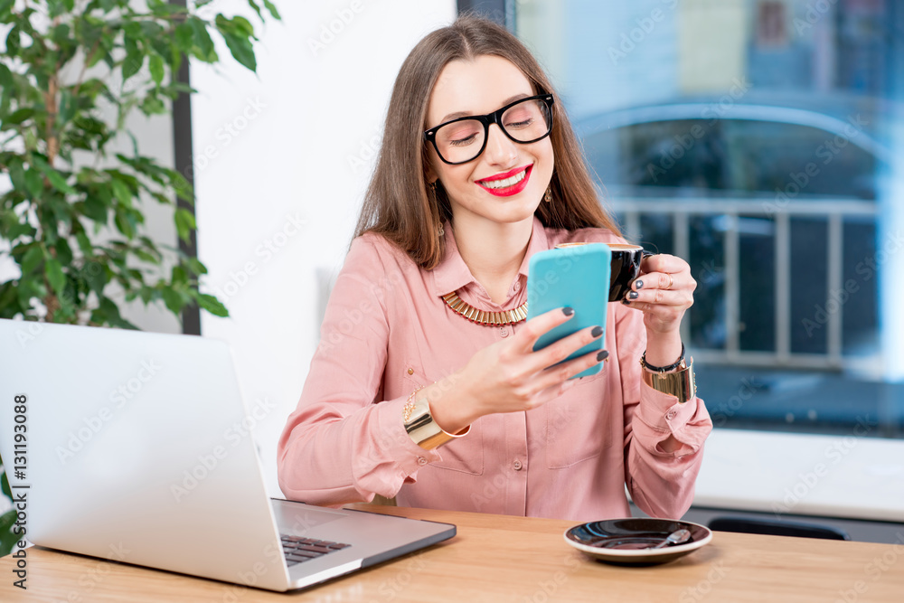 Businesswoman sitting with coffee, smartphone and laptop at the cafe Businesswoman sitting with coffee, smartphone and laptop at the cafe