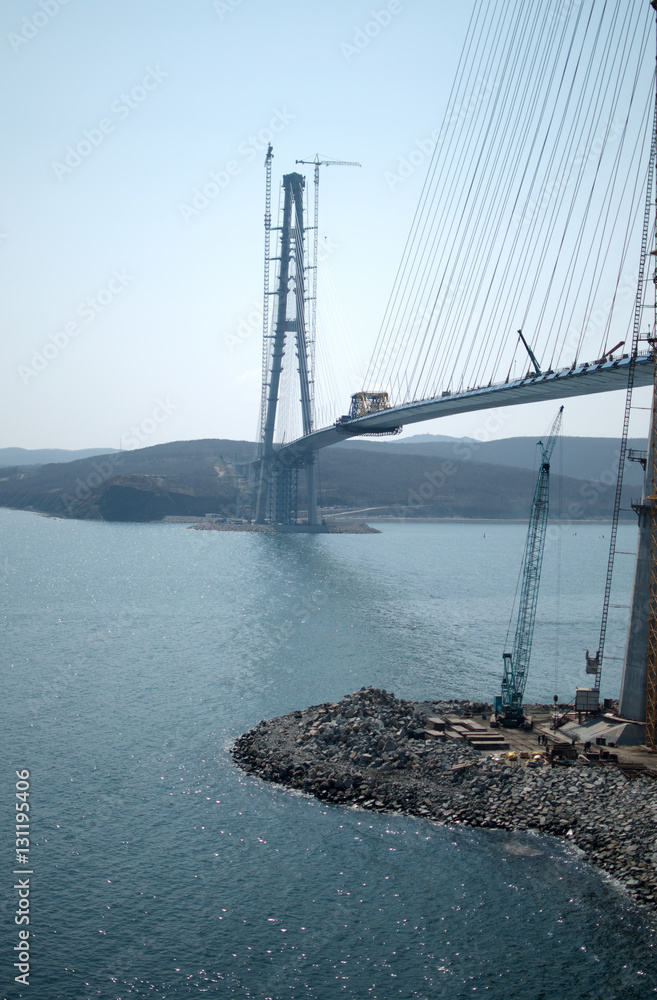 Fototapeta premium Construction of the cable-stayed bridge. Cable-stayed pylon in foreground