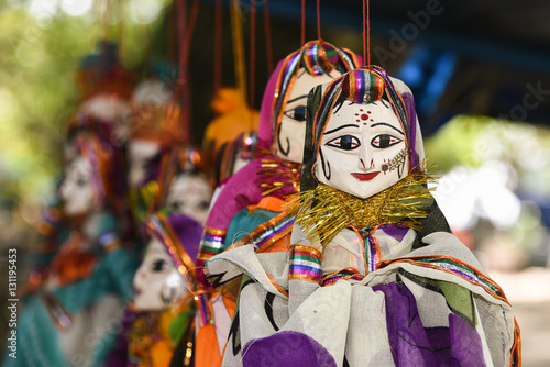 Hand made puppets attached to string in Rajasthan India dolls. Women face with traditional Indian makeup wearing saree / sari / lehenga /choli 