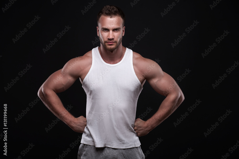 Studio portrait of athletic young man wearing white undershirt isolated on black background Studio portrait of athletic young man wearing white undershirt isolated on black background